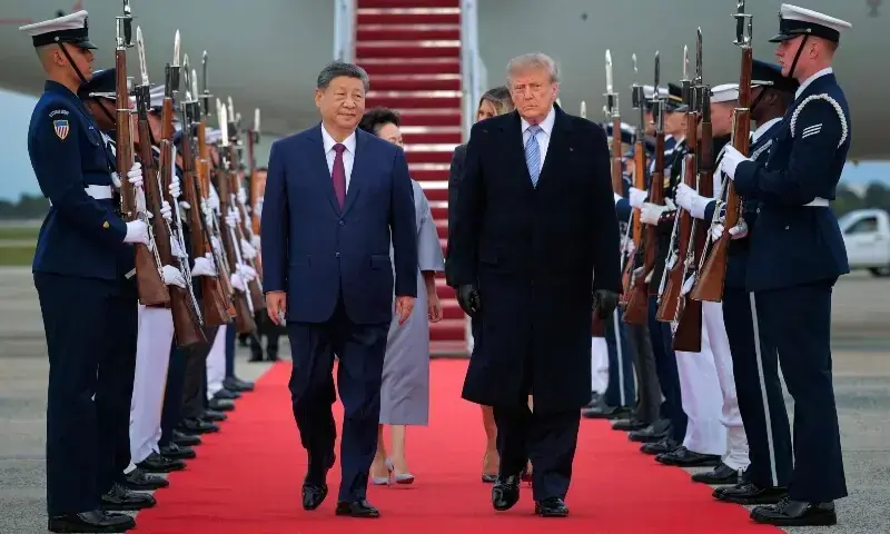 US President Donald Trump (R) walks on a red carpet after greeting Chinese President Xi Jinping (L) during an arrival ceremony on September 23, 2026 at Joint Base Andrews, Maryland. -- AFP