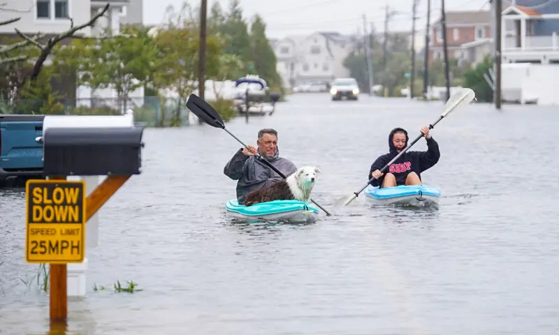 Residents kayak down a flooded road during a storm in Beach Haven West, New Jersey.&mdash;AFP