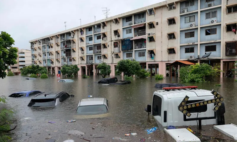 FLOODWATERS submerge cars next to residential buildings after heavy rain in Bangkok.&mdash;AFP