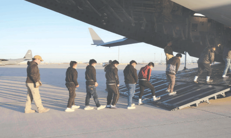 Security personnel guide shackled undocumented migrants to a military aircraft at Fort Bliss, Texas.—AFP/File Security personnel guide shackled undocumented migrants to a military aircraft at Fort Bliss, Texas.—AFP/File