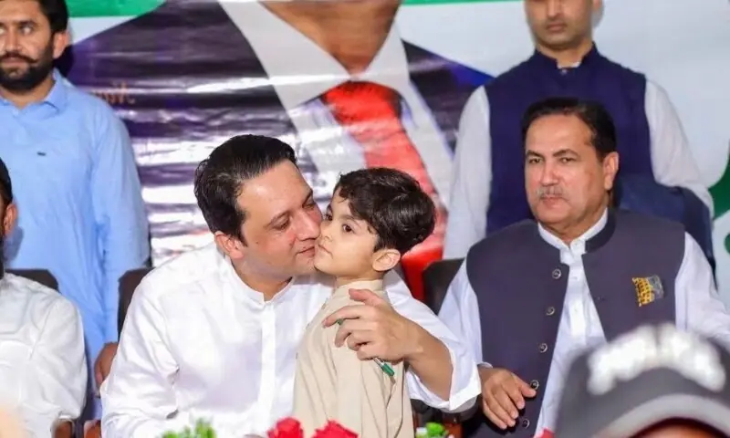 AJK Prime Minister Iftikhar Gillani kisses the grandson of Legislative Assembly Speaker Chaudhry Tariq Farooq, who is sitting next to him, at a function in Bhimber on Monday. -- Photo by author