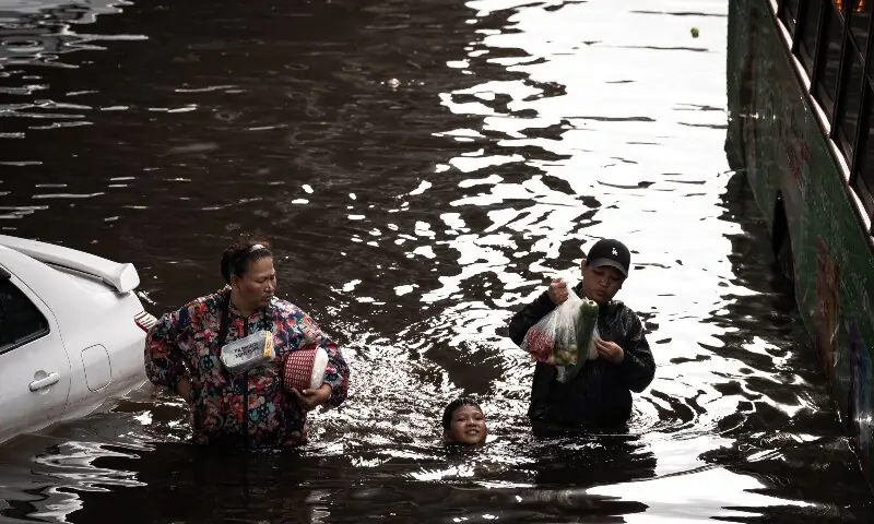 People walk through floodwaters in the Bang Kapi district of Bangkok on September 28, 2026. —AFP