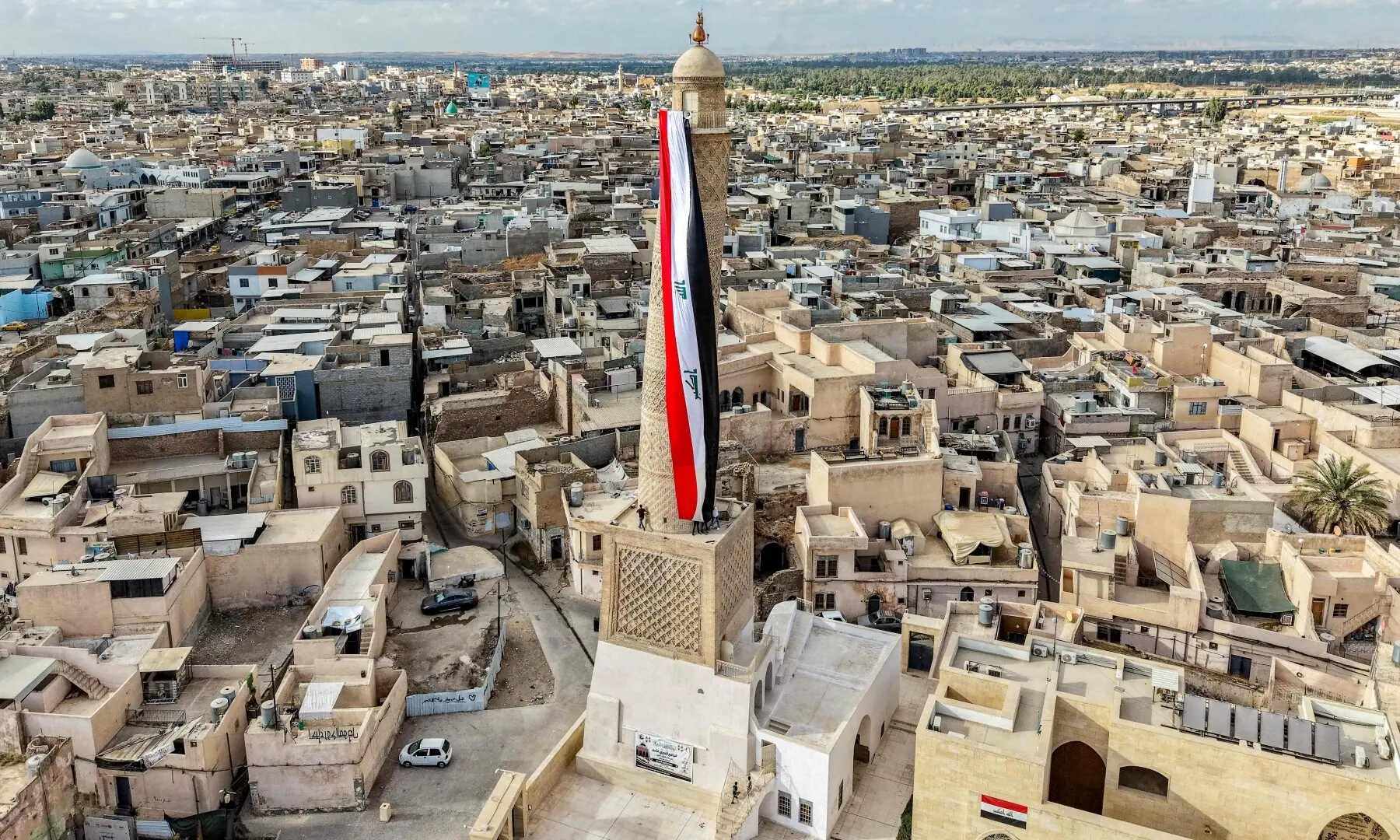 A giant Iraqi flag hangs off the reconstructed 12th century &ldquo;Hadba&rdquo; leaning minaret at the historic Great Mosque of al-Nuri in the old city of Mosul on September 29, 2026 as Iraq marks the withdrawal of the US-led anti-Islamic State coalition forces from the country. &mdash;AFP