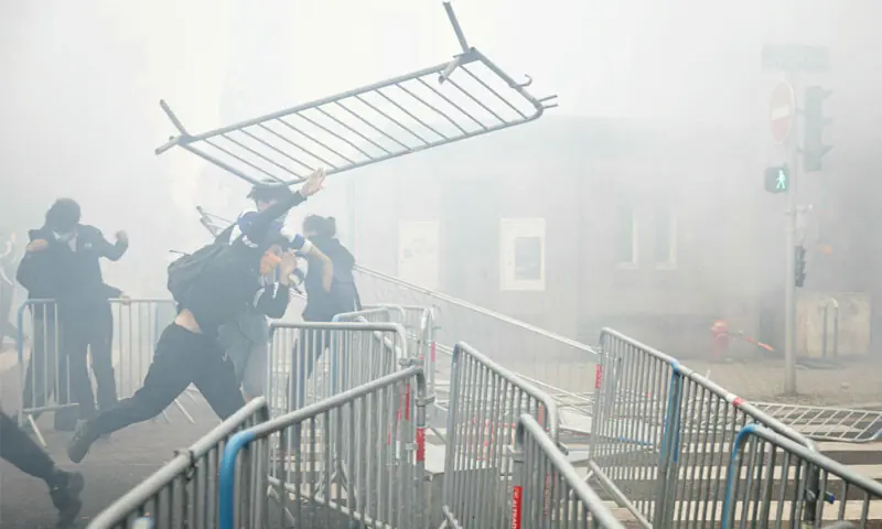 A student throws a barrier from a blockade at Strasbourg University.—AFP/Reuters A student throws a barrier from a blockade at Strasbourg University.—AFP/Reuters