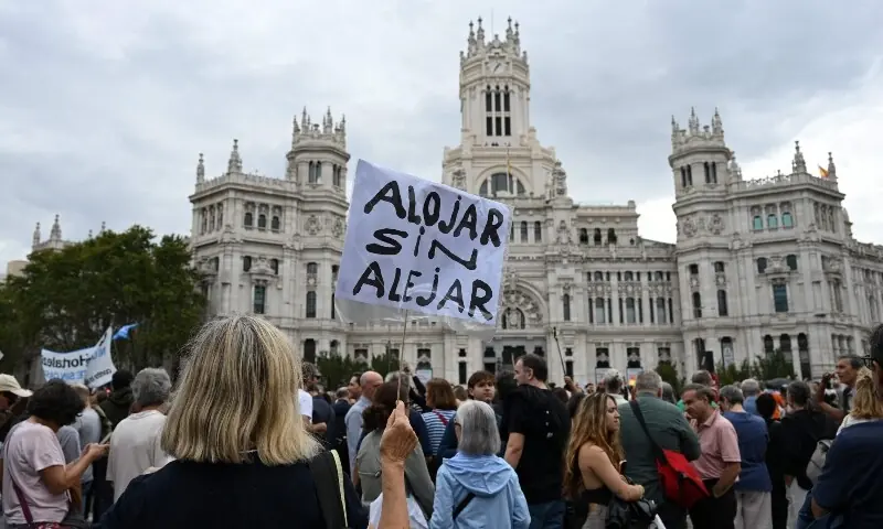 A demonstrator holds a banner reading &lsquo;Move in not move away&rsquo; during a protest against evictions and high rent prices on plaza de Cibeles in Madrid, Spain on October 3, 2026. &mdash; AFP