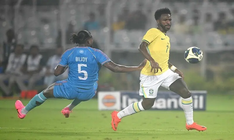 Brazil's Vinicius Junior (R) vies for the ball with Bijoy Varghese of India during their international friendly match at the Salt Lake Stadium in Kolkata on October 3, 2026. &mdash;AFP