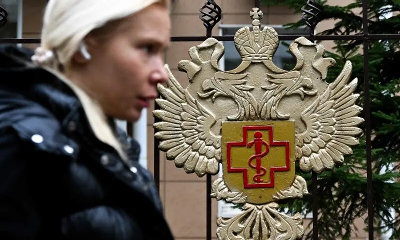 A woman walks past the logo of Russia&rsquo;s consumer and health watchdog Rospotrebnadzor sitting on its grounds&rsquo; fencing in Moscow, Russia on October 5, 2026. &mdash; AFP