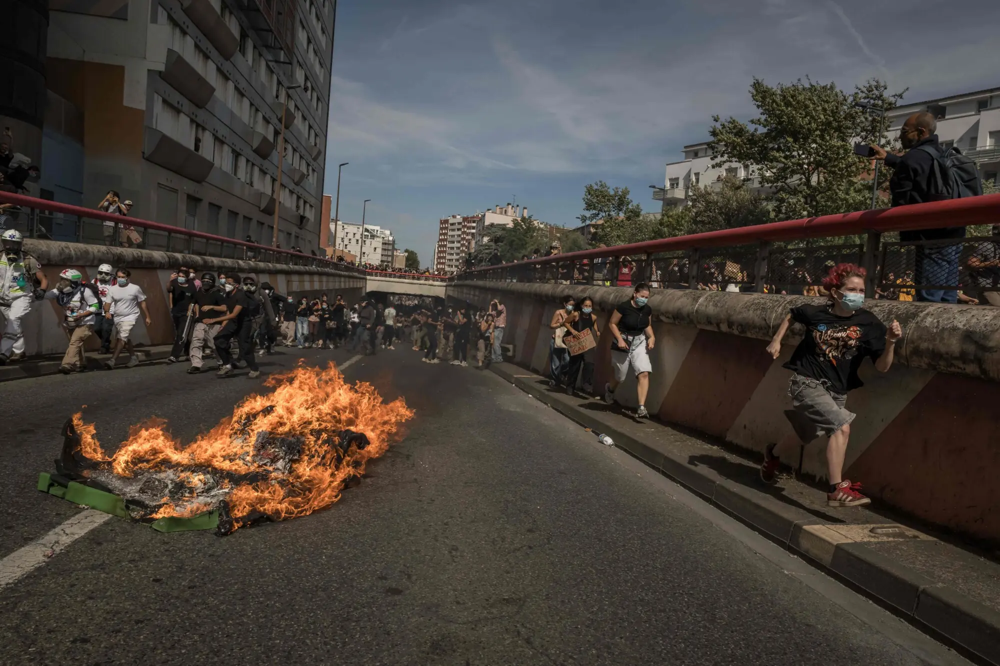 Protesters march along a road past a burning garbage bin during a demonstration of high-school students as part of a nationwide protest movement over learning conditions in Toulouse, on October 6, 2026. — AFP