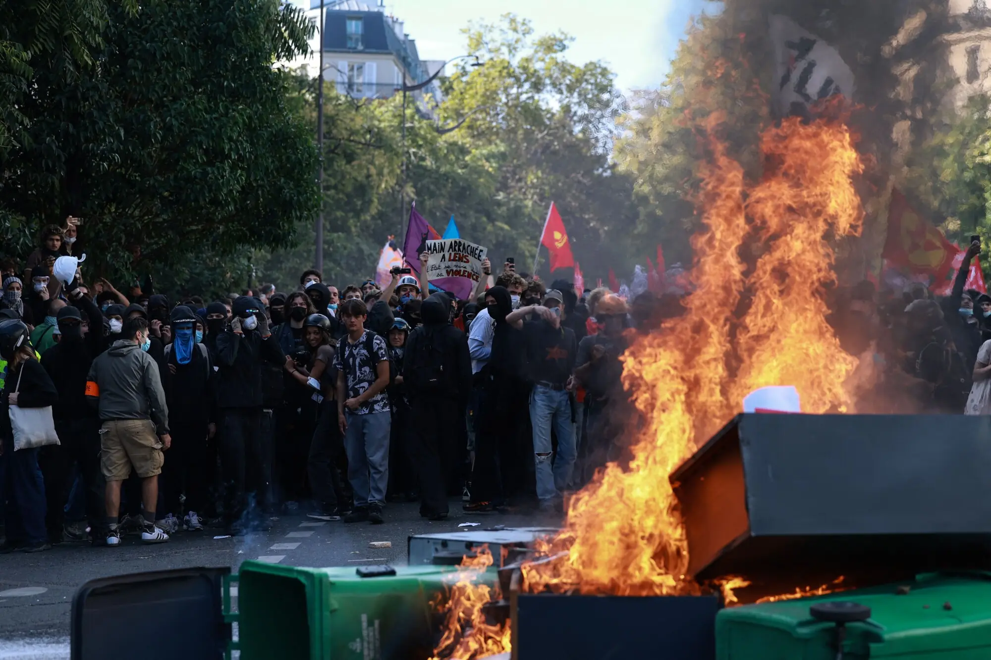 Protesters stand in front of bins and furnitures set on fire during a demonstration of high-school students, in Paris on October 6, 2026, as part of a nationwide protest movement over learning conditions. — AFP