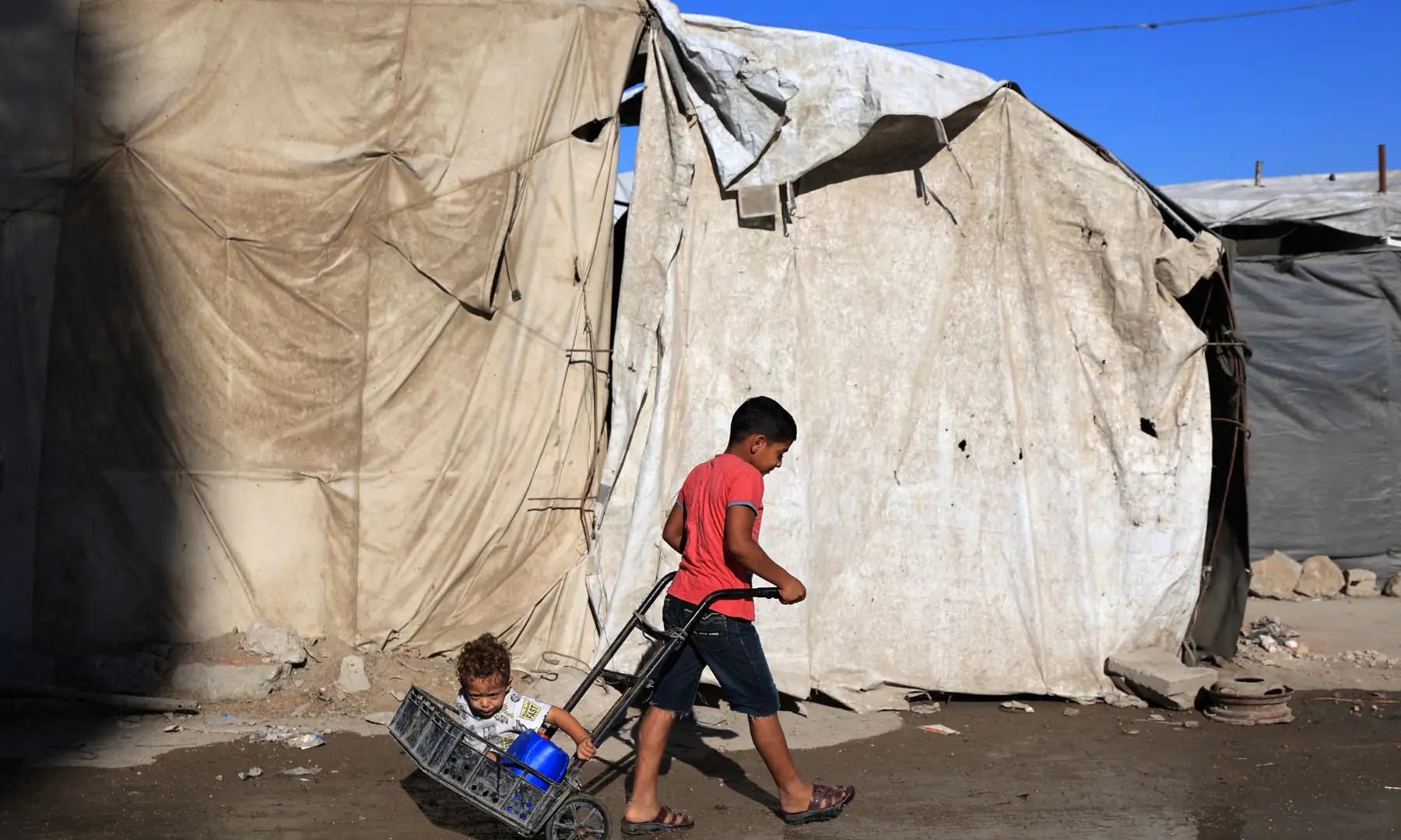 Children of displaced Palestinians play outside their temporary tent in Gaza City on Oct 7, 2026. &mdash; AFP