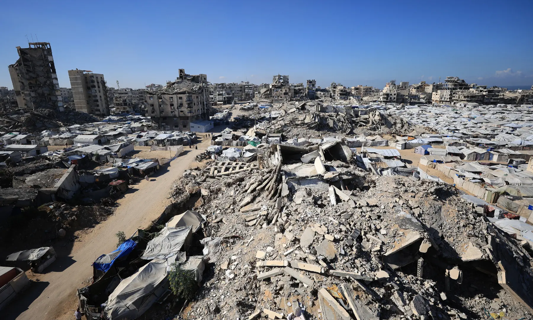 A view of the temporary tents of displaced Palestinians is pictured along destroyed buildings in Gaza City on Oct 7, 2026.  &mdash; AFP
