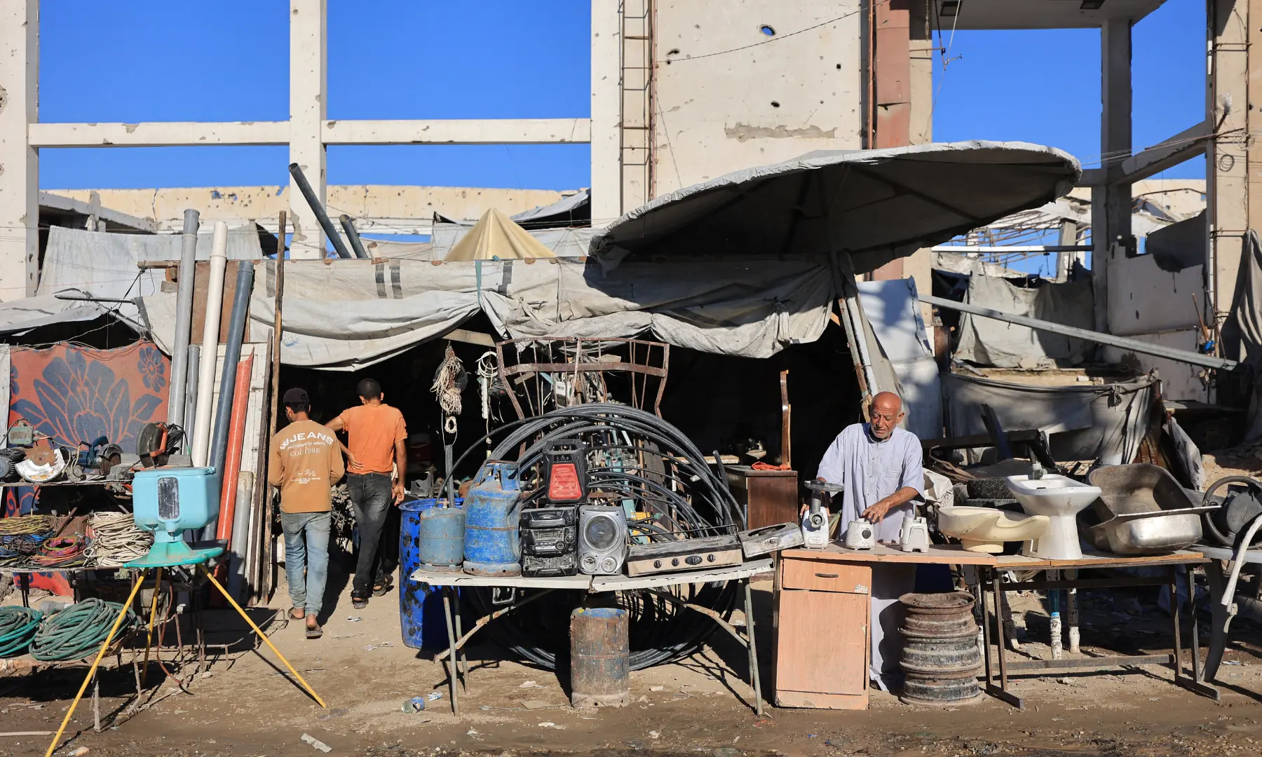 A Palestinian scrapdealer arranges products at his roadside stall in Gaza City on Oct 7, 2026. &mdash; AFP
