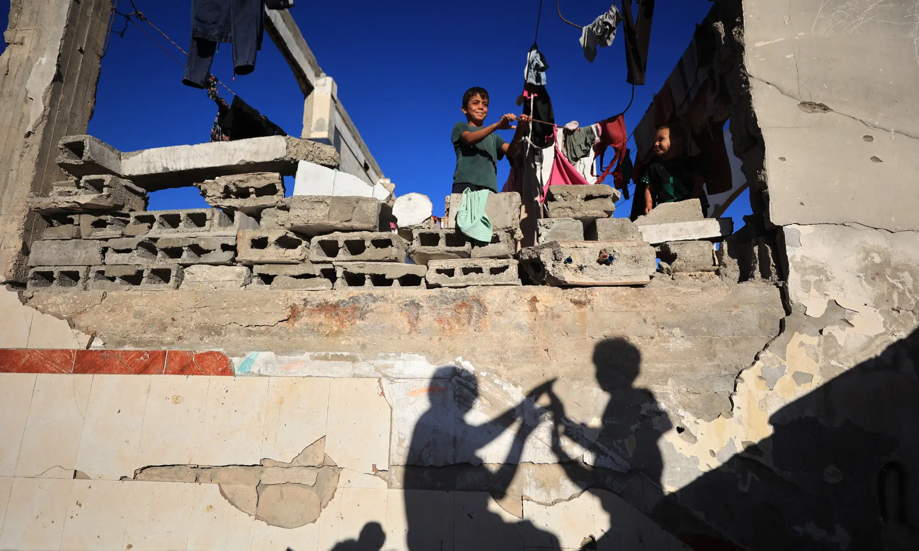 Children of displaced Palestinians, play on a destroyed building in Gaza City on Oct 7, 2026. &mdash; AFP
