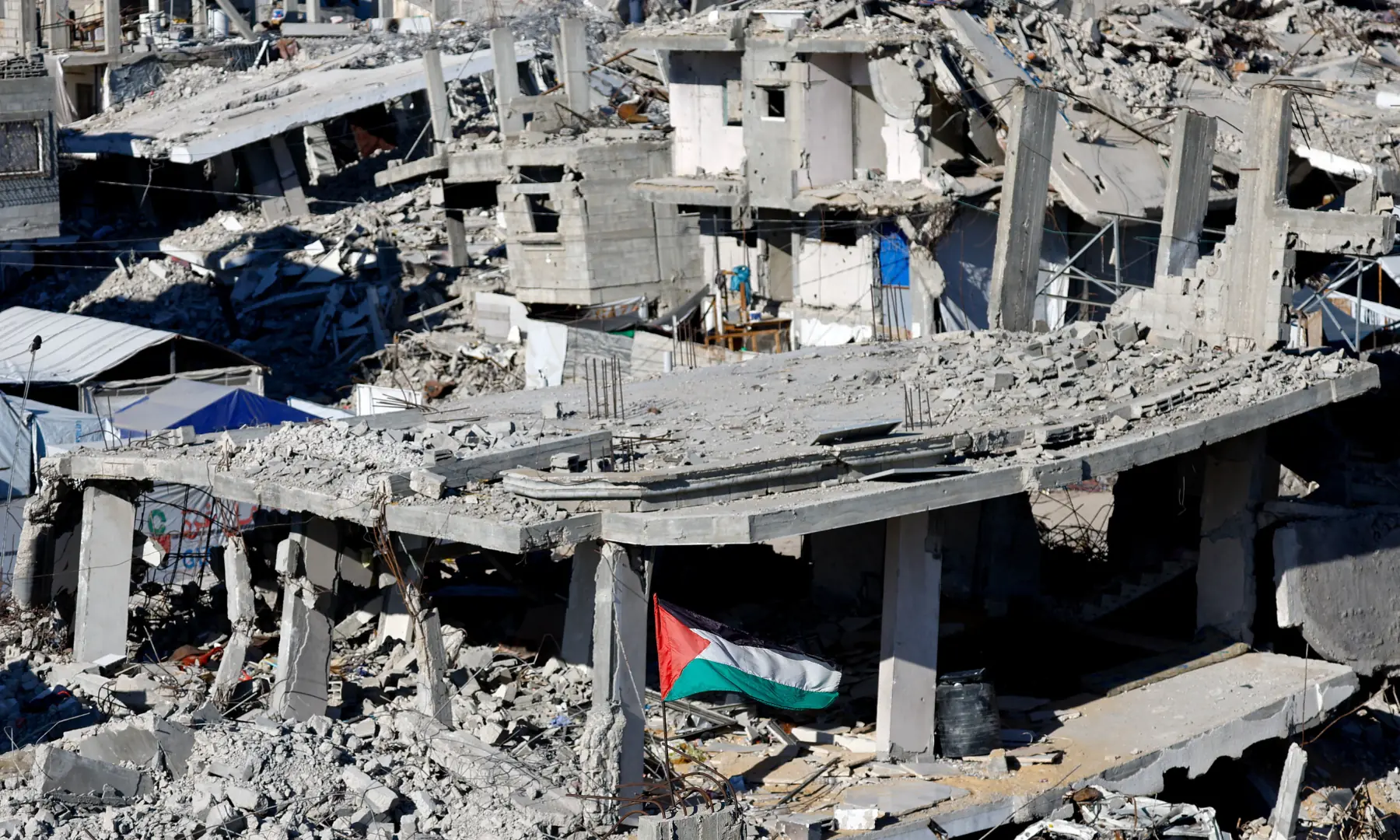 A Palestinian flag amid the ruins of buildings destroyed during the war, in Gaza City, on Oct 7, 2026. &mdash; Reuters