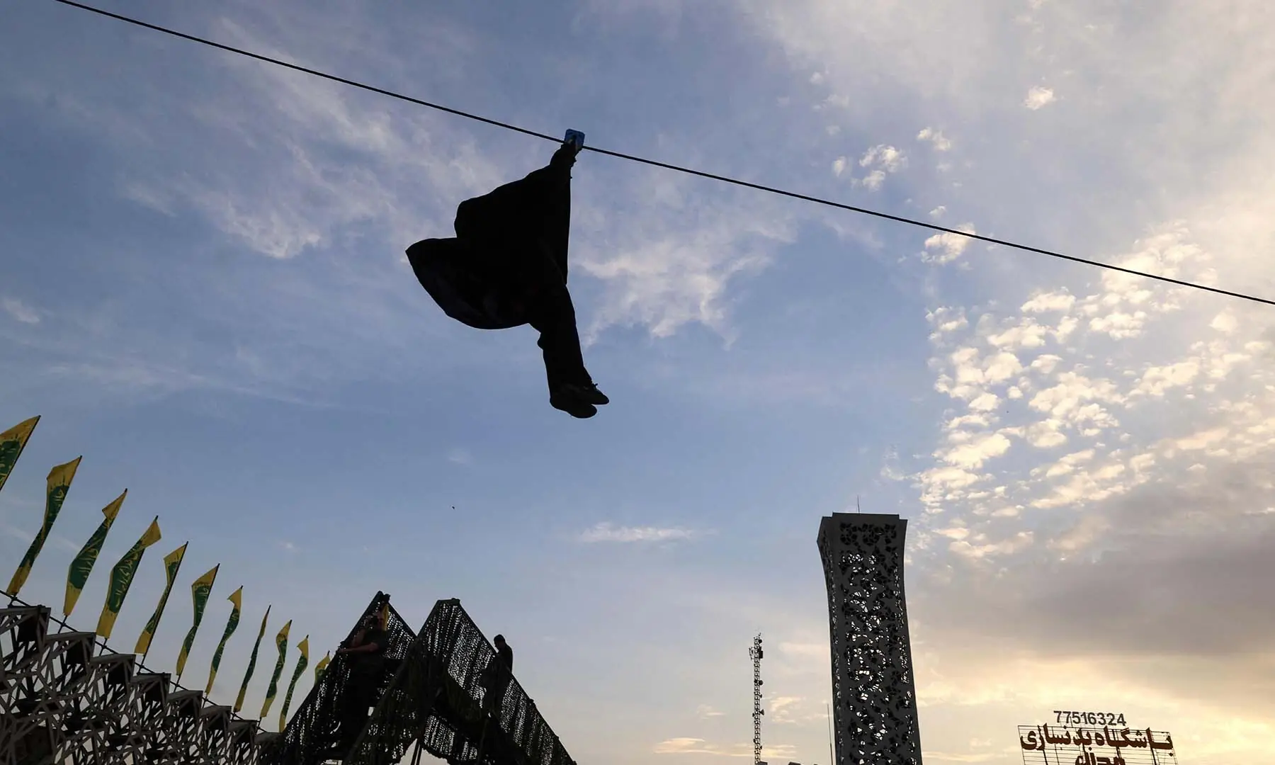 An Iranian woman rides a zipline during a military course for volunteers at the Janfada training camp set up in Imam Hussein square in Tehran, Iran on October 6, 2026. &mdash; AFP