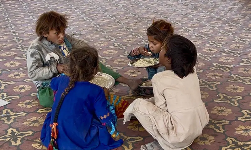 Children share a meal in the courtyard of the Sant Nenuram Ashram in Islamkot, Sindh Children share a meal in the courtyard of the Sant Nenuram Ashram in Islamkot, Sindh