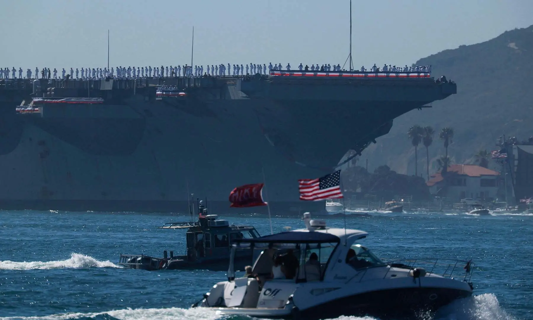 Crew members stand on the deck as the USS Abraham Lincoln aircraft carrier approaches its homeport at Naval Air Station North Island on return from its historic 10-month deployment to the Middle East on October 8, 2026 as seen from the Port of San Diego in San Diego, California. &mdash; AFP