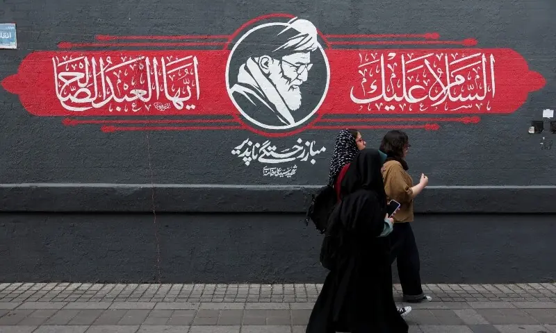 People walks past a mural depicting Iran's late Supreme Leader Ayatollah Ali Khamenei, in Tehran, Iran, October 7. &mdash; Reuters