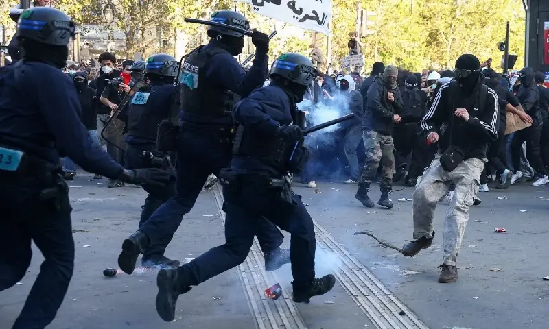 Police officers in riot gear run towards a demonstrator amid clashes during nationwide protests in Paris, France on October 8, 2026, to demand better school conditions. &mdash;Reuters