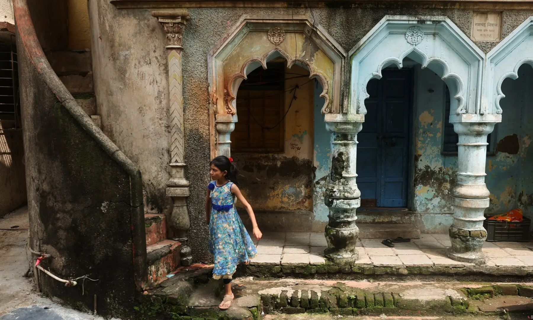 A girl walks past a house in a residential area near the site of an Amazon data centre in Thane, India on September 22, 2026. —Reuters