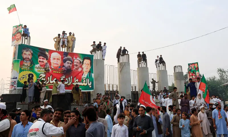 PARTICIPANTS of the PTI’s protest march climb the pillars of an under-construction elevated thoroughfare lined up on the outskirts of Peshawar.—Reuters PARTICIPANTS of the PTI’s protest march climb the pillars of an under-construction elevated thoroughfare lined up on the outskirts of Peshawar.—Reuters