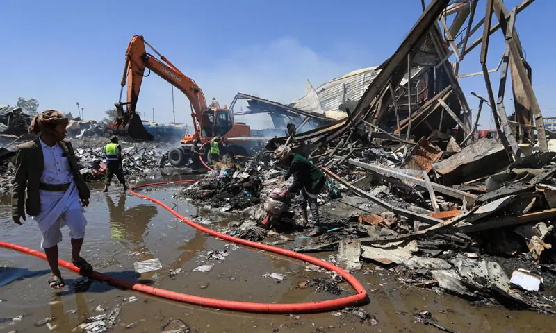 YEMENIS assess the damage as emergency personnel extinguish a fire at the site of a reported overnight Saudi air strike on a foam factory in Sanaa’s Al-Rawda neighbourhood.—AFP YEMENIS assess the damage as emergency personnel extinguish a fire at the site of a reported overnight Saudi air strike on a foam factory in Sanaa’s Al-Rawda neighbourhood.—AFP