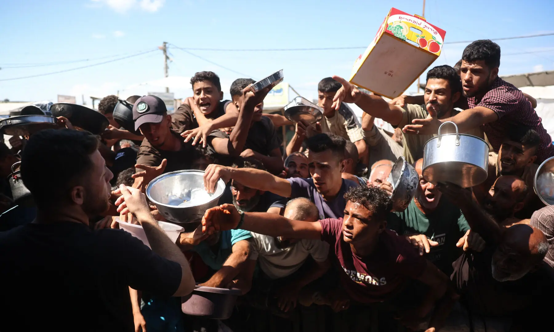 This photo taken on Oct 6, 2026 shows displaced Palestinians waiting to receive food at a charity kitchen in Khan Younis, in the southern Gaza Strip. — AFP