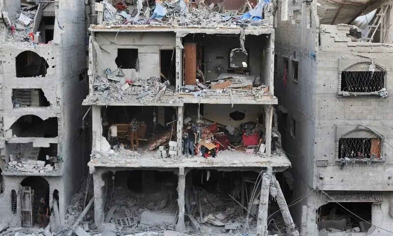 Palestinians inspect the site of a house targeted by Israeli airstrikes after the Israeli military warned residents to evacuate late on Thursday evening, in Gaza City, October 9. &mdash; Reuters