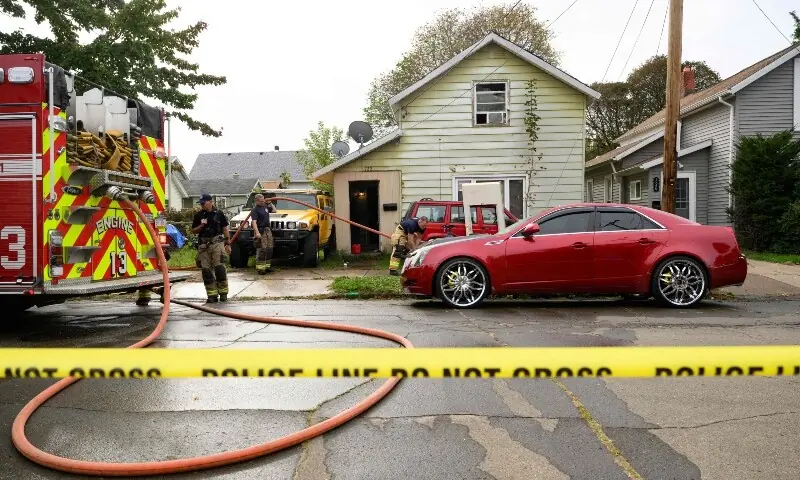 Firefighters clean blood from outside the home at 722 Perry Street where 9 members of a family were killed in an apparent domestic dispute on October 10, 2026 in Erie, Pennsylvania. &mdash;Getty Images via AFP