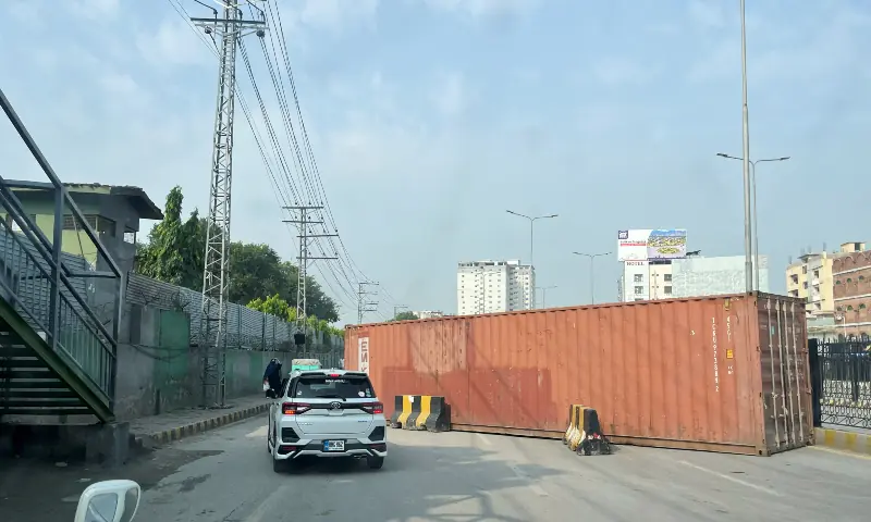 A vehicle moves past a shipping container used to block a road leading to the Red Zone, in Peshawar on October 11, 2026. — Reuters A vehicle moves past a shipping container used to block a road leading to the Red Zone, in Peshawar on October 11, 2026. — Reuters
