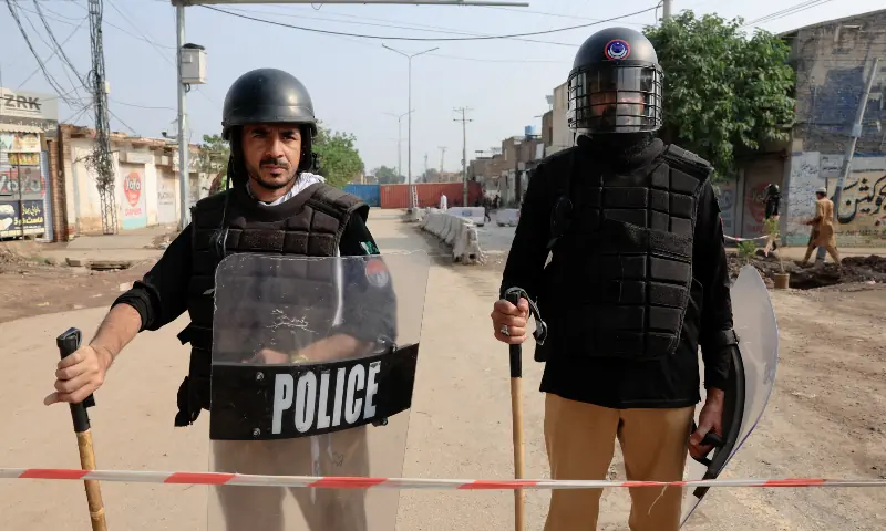 Members of the police stand guard near shipping containers blocking a road leading to the Red Zone in Peshawar on October 11, 2026. — Reuters Members of the police stand guard near shipping containers blocking a road leading to the Red Zone in Peshawar on October 11, 2026. — Reuters