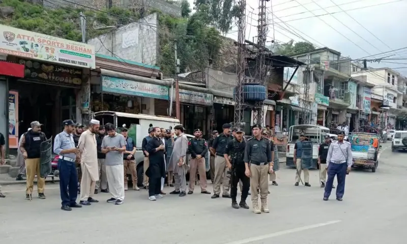 Police personnel stand guard on a road in Shangla. — Umar Bacha