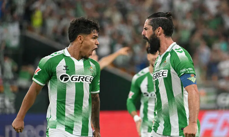 SEVILLE: Real Betis’ Isco (R) celebrates with team-mate Juan Hernandez after scoring against Osasuna during their La Liga match at the La Cartuja Stadium.—AFP SEVILLE: Real Betis’ Isco (R) celebrates with team-mate Juan Hernandez after scoring against Osasuna during their La Liga match at the La Cartuja Stadium.—AFP