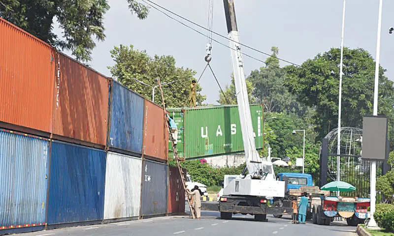 The capital administration uses a crane to remove containers placed on the roadside near Serena Chowk in Islamabad on Monday. — Photo by Mohammad Asim The capital administration uses a crane to remove containers placed on the roadside near Serena Chowk in Islamabad on Monday. — Photo by Mohammad Asim