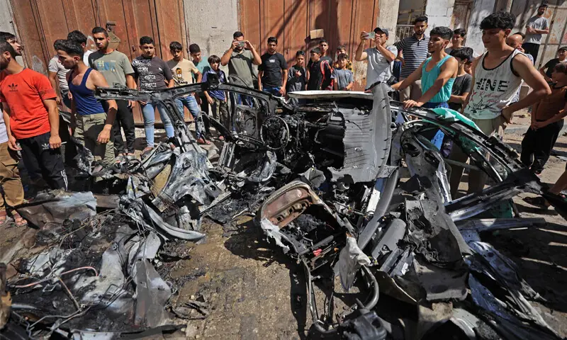 Palestinians inspect the wreckage of a car after it was destroyed in an Israeli strike at Tuffah, a neighbourhood of Gaza City.&mdash;AFP