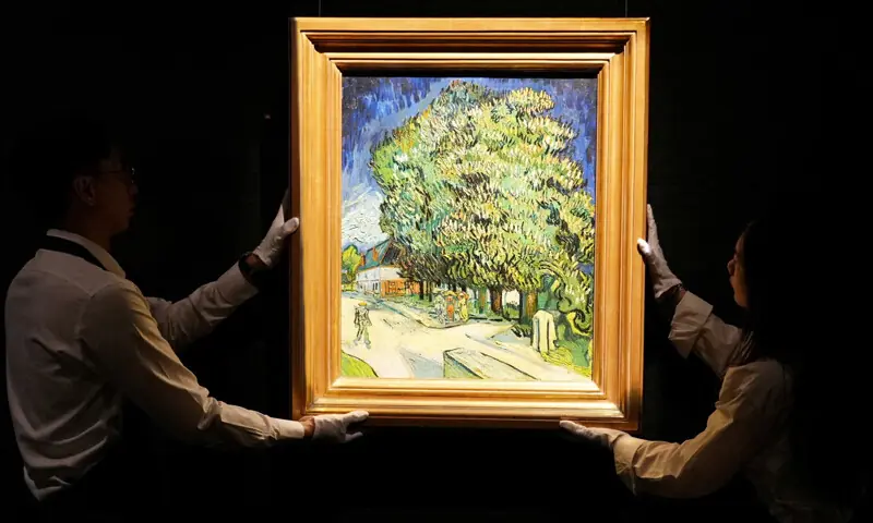 HONG KONG: Staff members pose with Vincent van Gogh’s Chestnut Trees in Blossom at a media preview ahead of its auction in New York.—Reuters HONG KONG: Staff members pose with Vincent van Gogh’s Chestnut Trees in Blossom at a media preview ahead of its auction in New York.—Reuters