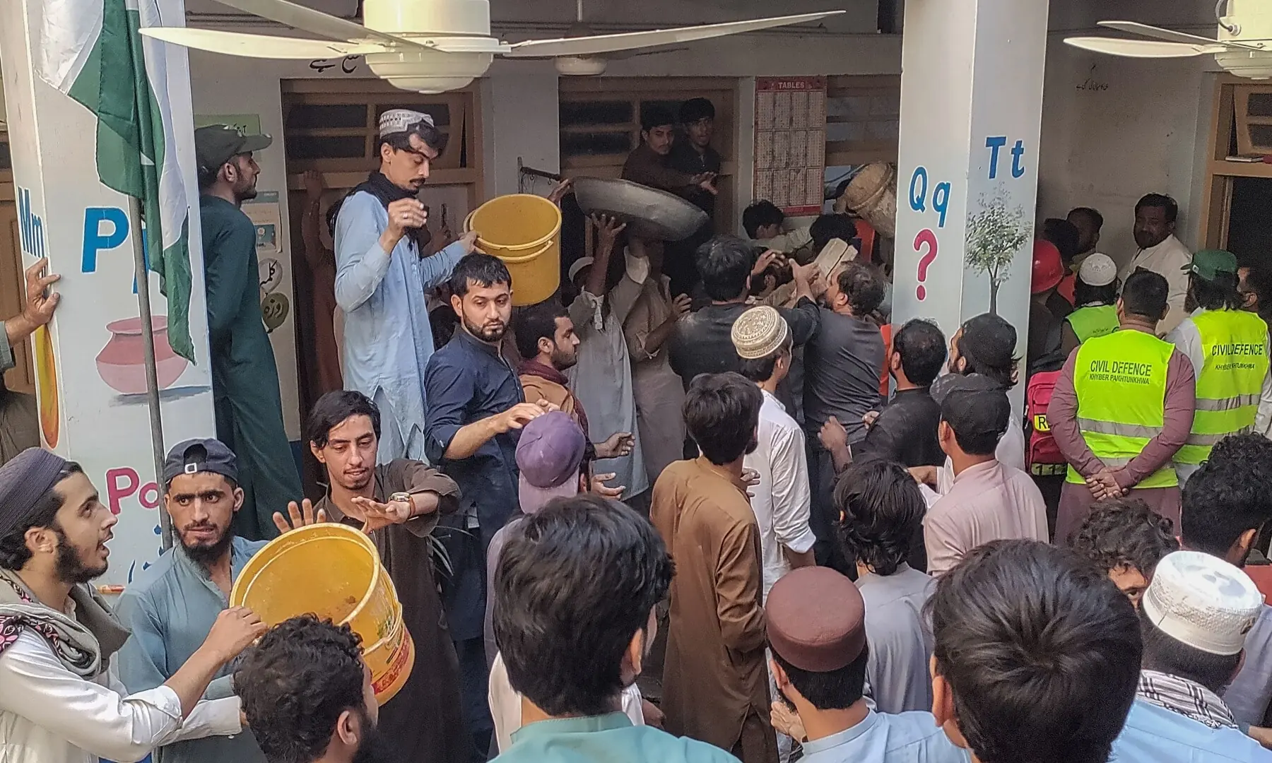 Residents and rescue workers gather near an ambulance after a school roof collapse in Peshawar Pakistan on October 15.&mdash;Reuters