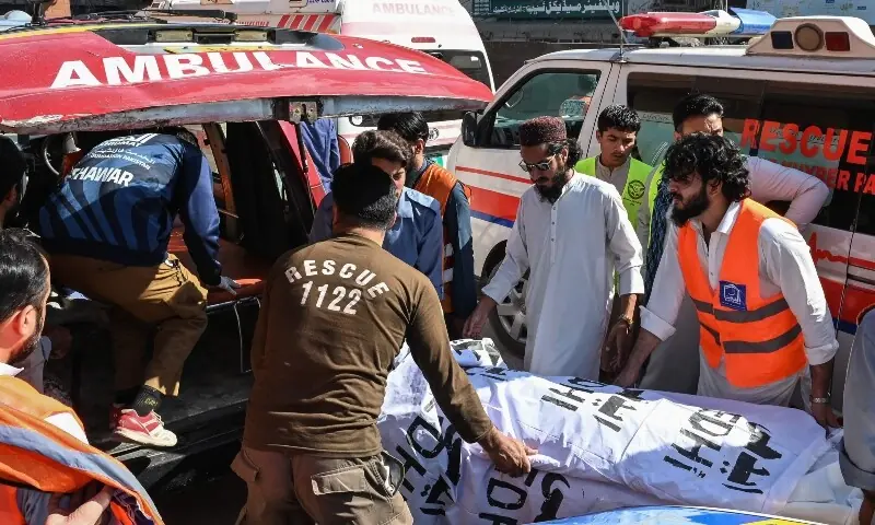 Volunteers and relatives shift the body of a victim, killed after a roof collapsed at a school, into an ambulance outside a hospital in Peshawar on October 15, 2026. &mdash;AFP