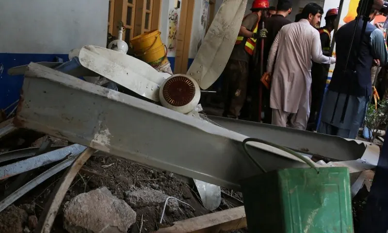 People stand near rubble after a school roof collapse in Peshawar, October 15, 2026. &mdash;Reuters