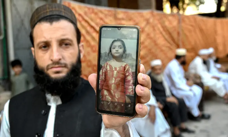 A father shows a photograph of his daughter, who got killed after a roof collapsed at a school, in Peshawar on October 16, 2026. — AFP A father shows a photograph of his daughter, who got killed after a roof collapsed at a school, in Peshawar on October 16, 2026. — AFP