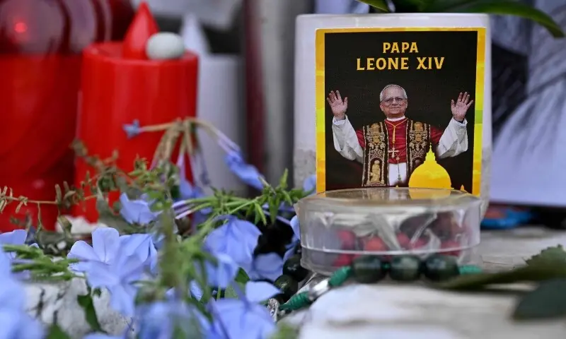 Flowers, candles and a picture of Pope Leo XIV are laid at the statue of John Paul II outside the Gemelli University Hospital, where Pope Leo XIV is recovering after undergoing surgery to remove a cancerous tumour from his right lung, in Rome, Italy on October 17, 2026. — AFP