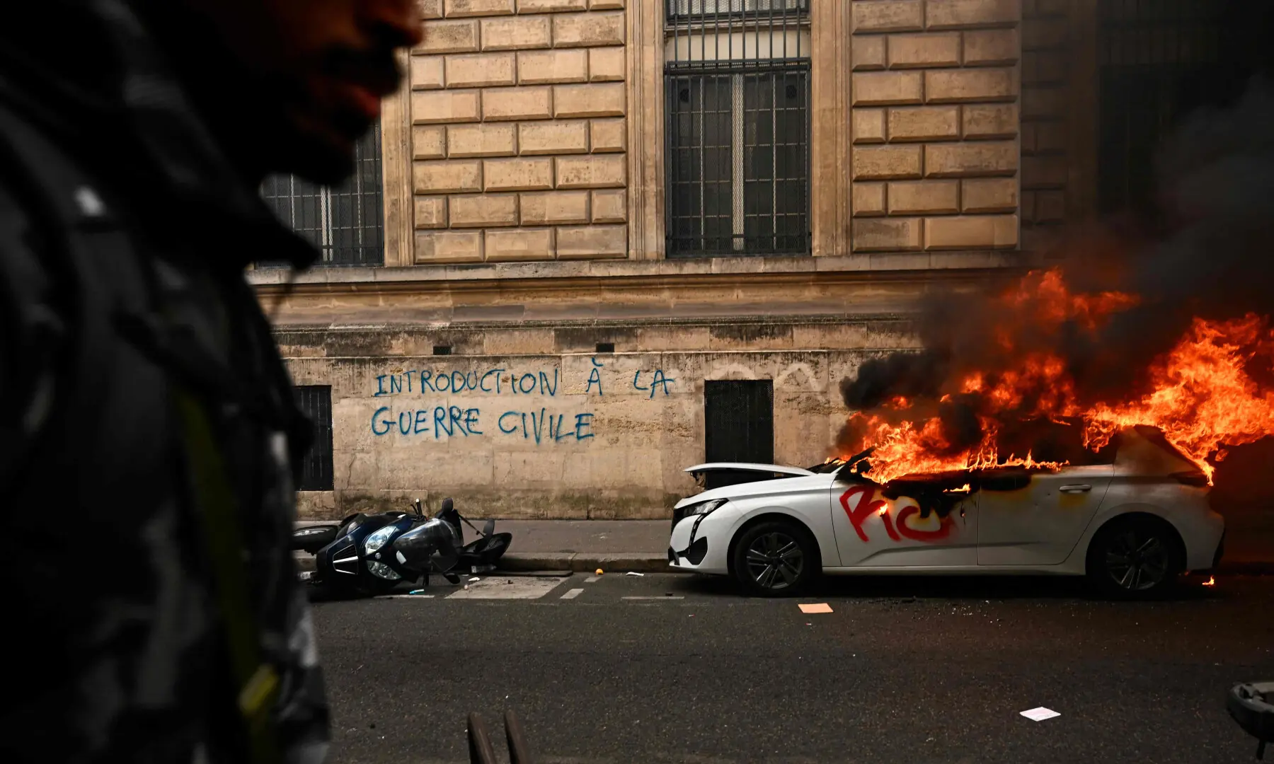  A car burns near a graffiti reading &ldquo;introduction to civil war&rdquo; as clashes erupted during a demonstration against the &ldquo;high cost of living&rdquo;, in Paris on Oct 17, 2026. &mdash; AFP 