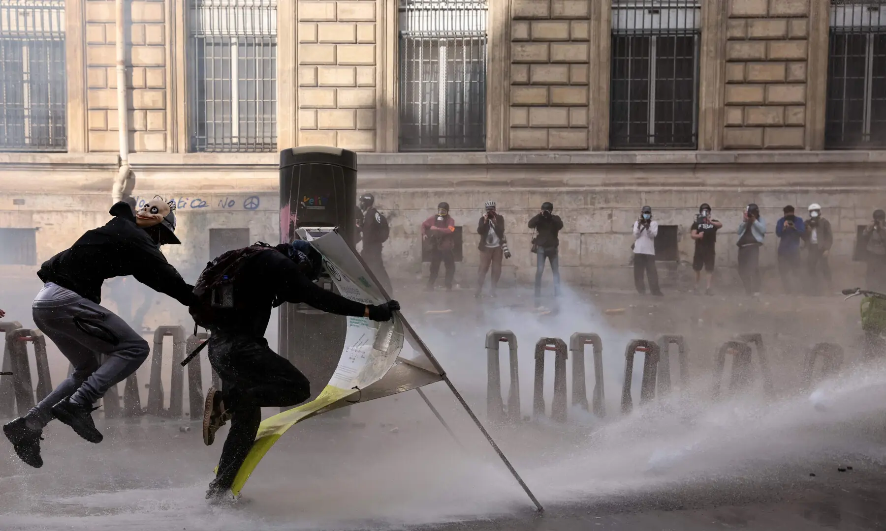  Protesters shield themselves from police water cannons during a demonstration to protest against the &ldquo;high cost of living&rdquo;, at Place de la Republique in Paris on Oct 17, 2026. &mdash; AFP 