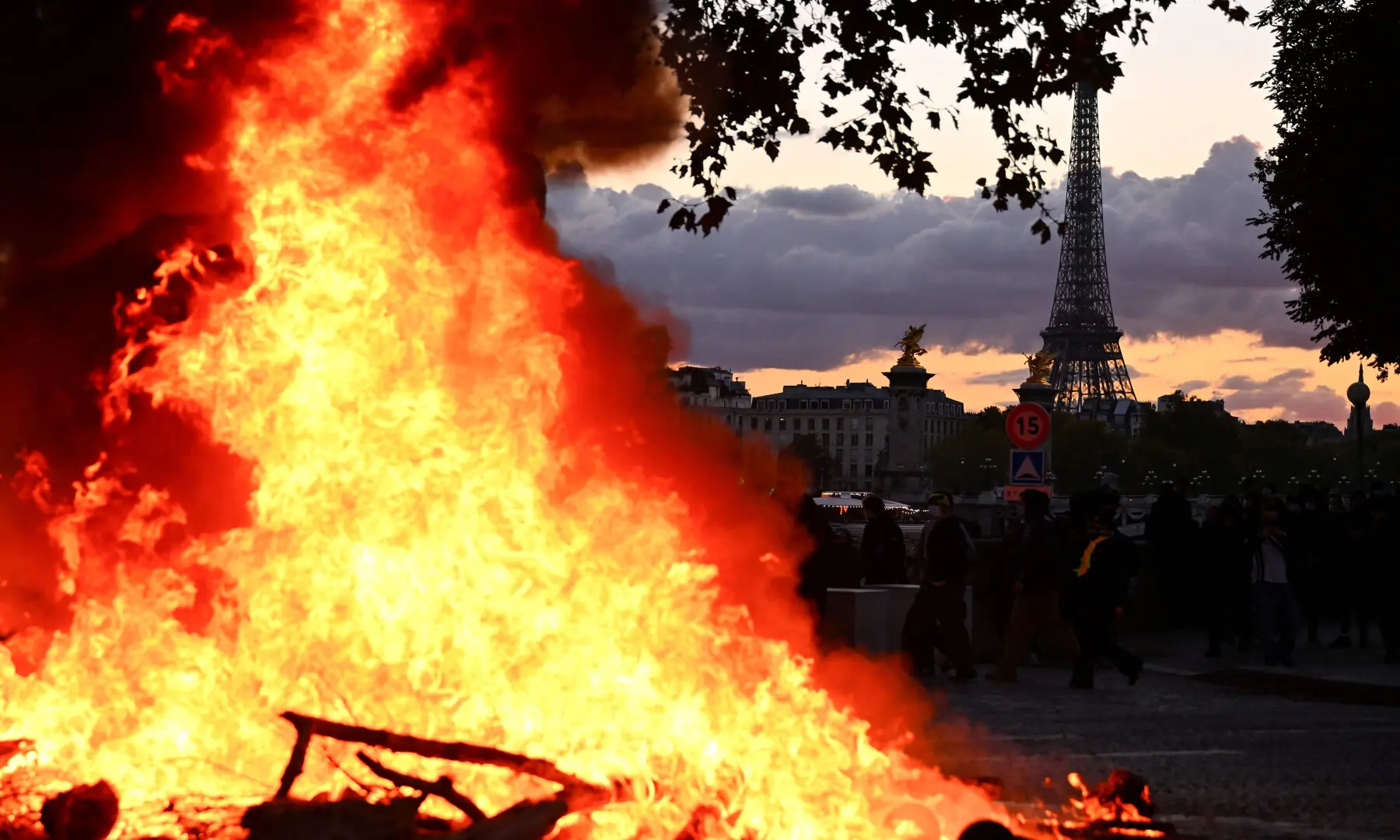  A fire is seen with the Eiffel Tower in the background during a demonstration to protest against the &ldquo;high cost of living&rdquo;, in Paris on Oct 17, 2026. &mdash; AFP 