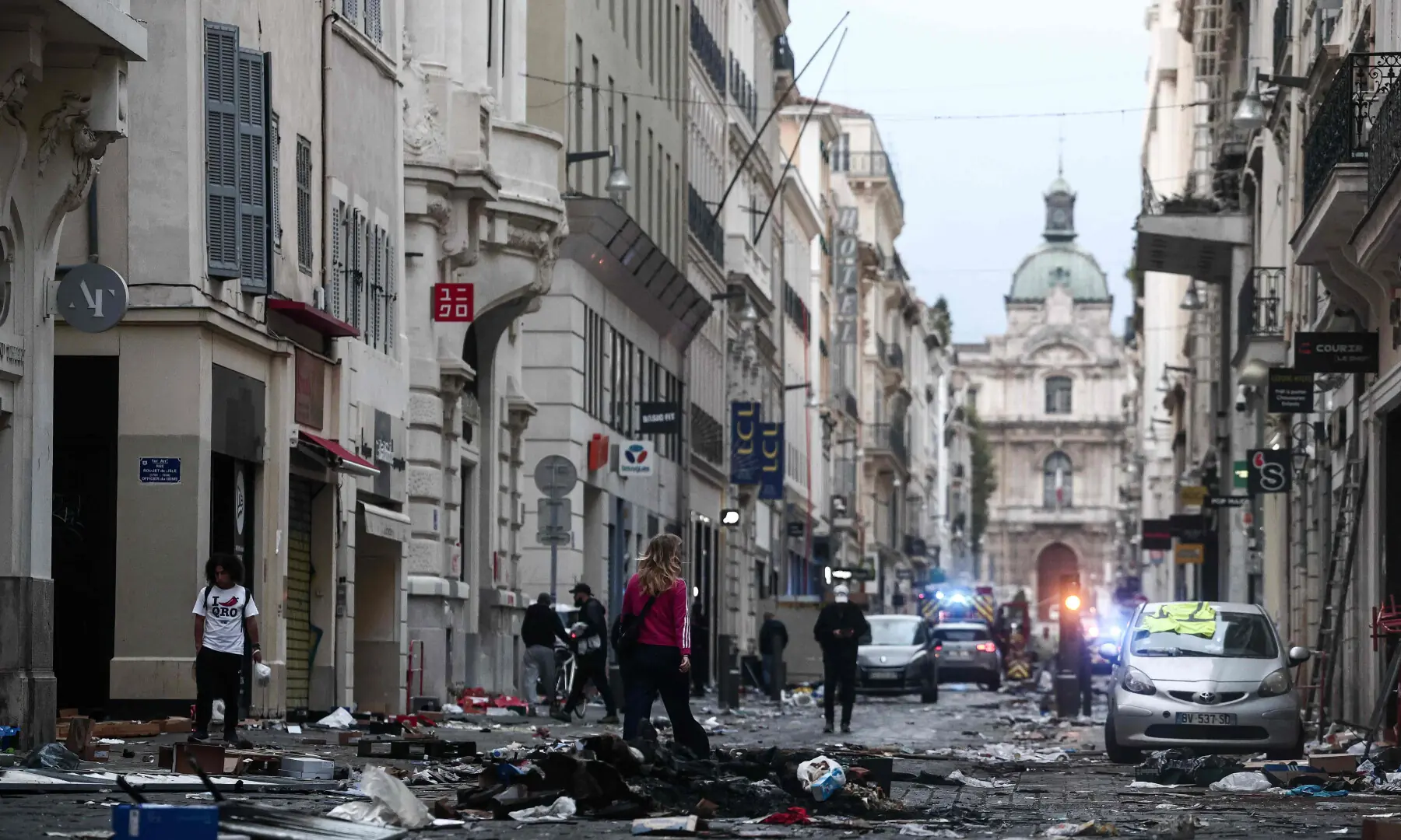  Pedestrians walk along a street covered in debris a day after nationwide protests against the &ldquo;high cost of living&rdquo;, in Marseille on Oct 18, 2026. &mdash; AFP 