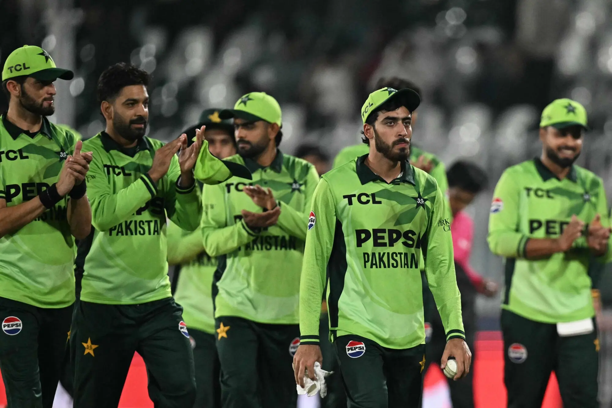 Arafat Minhas walks off the field with team-mates after helping Pakistan crush England in their tri-series match at the Rawalpindi Cricket Stadium on October 20, 2026.&mdash;AFP