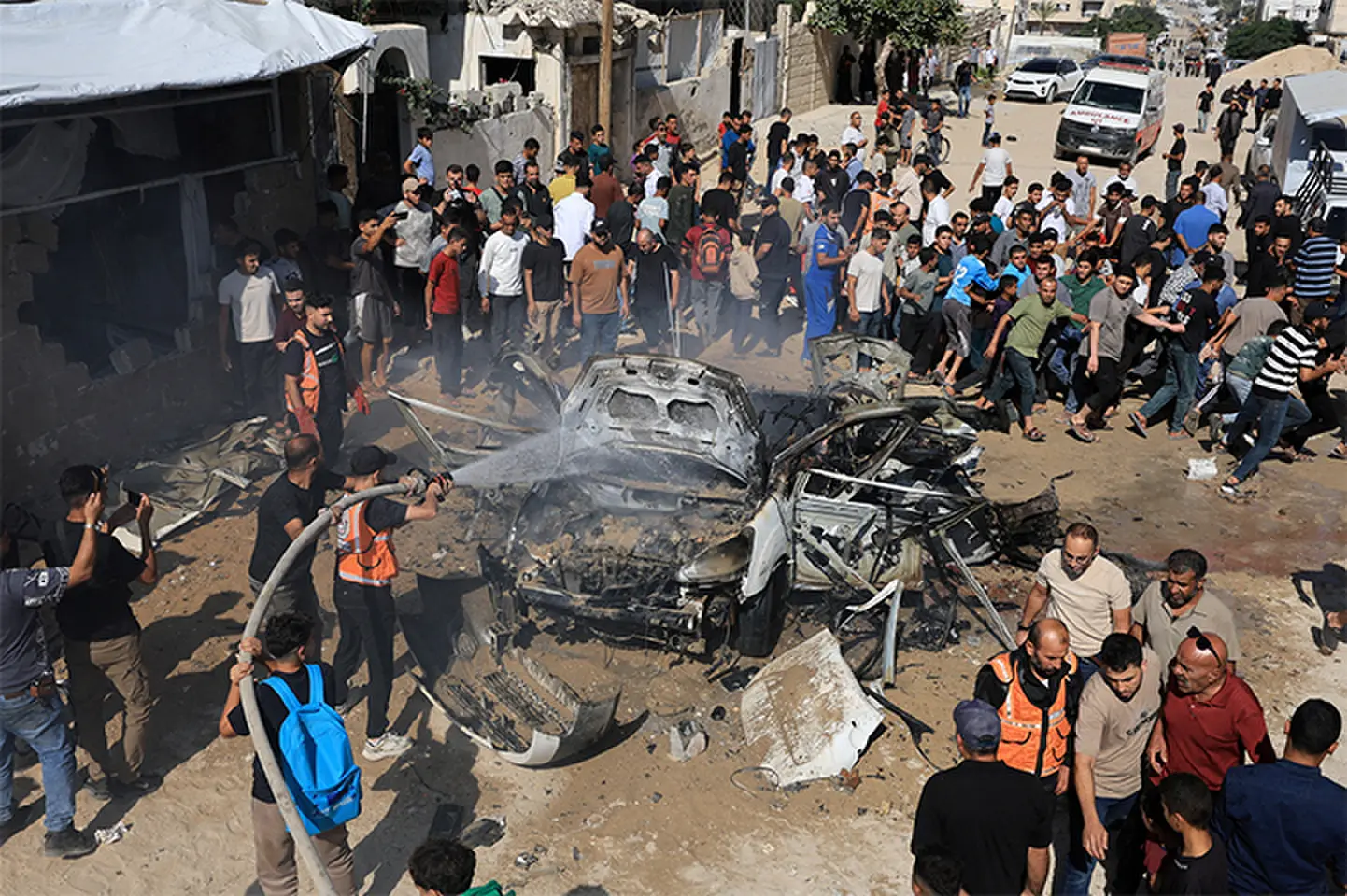Palestinians gather around the remains of a vehicle after it was hit by an Israeli strike in Gaza City. —Reuters Palestinians gather around the remains of a vehicle after it was hit by an Israeli strike in Gaza City. —Reuters