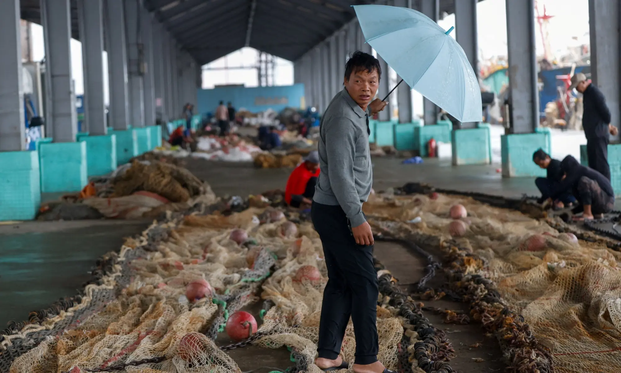 A fisherman walks among fishing nets at a fishing port as Typhoon Champi approaches Taiwan, in Keelung, Taiwan on October 23, 2026. &mdash;Reuters
