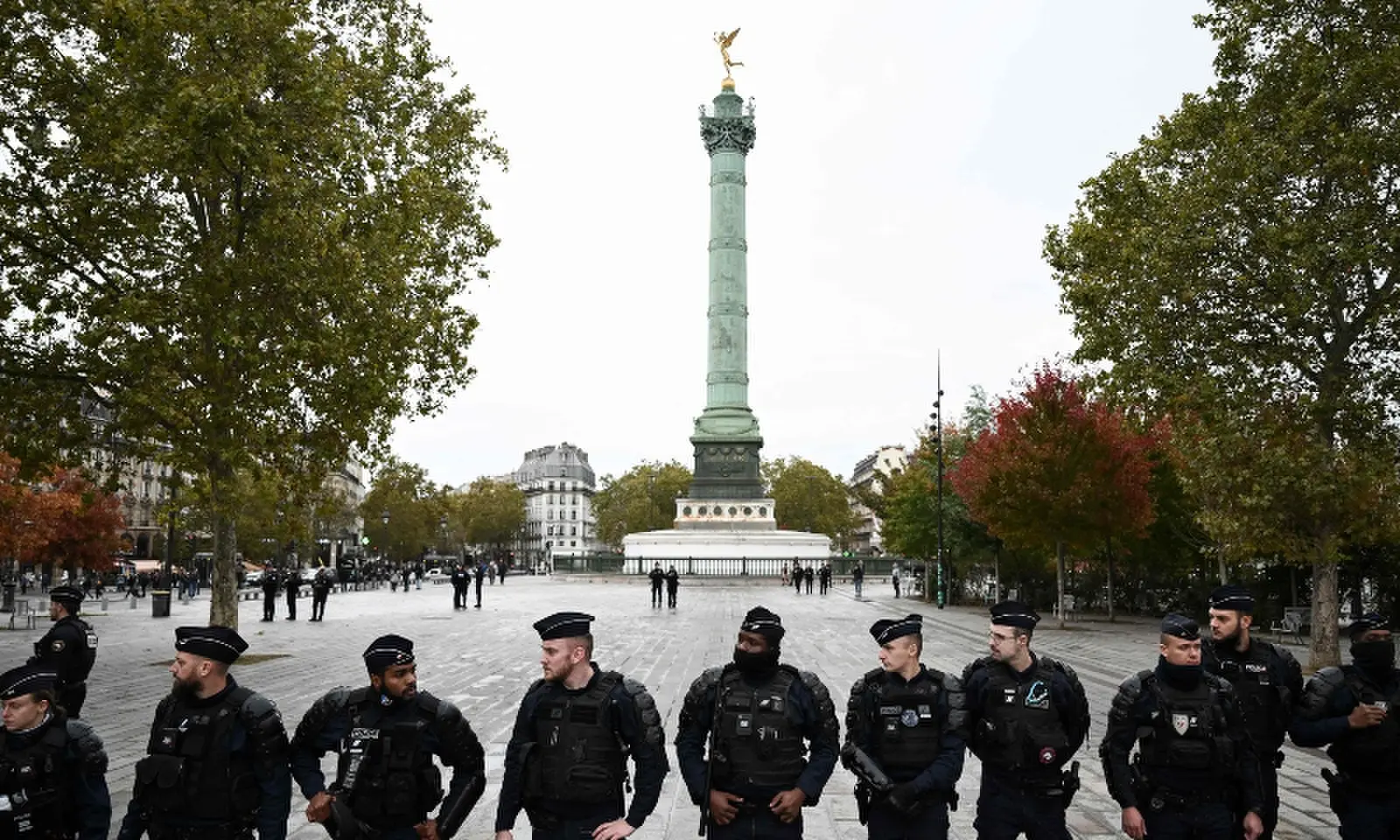 Police officers stand guard at the Place de la Bastille with The July Column in the background ahead of a demonstration in Paris, France on October 24, 2026. — AFP