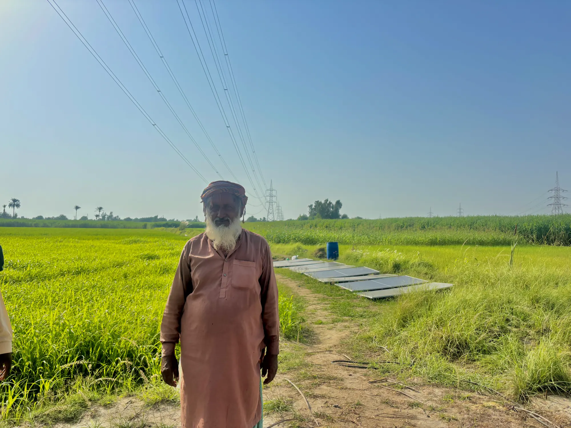  Ghulam Fareed stands in front of his solar panels in the fields 